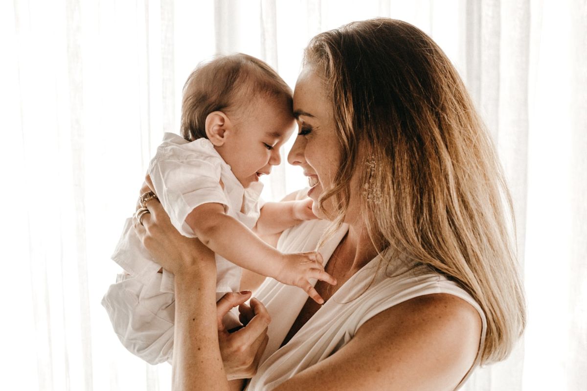 Mamá sonriendo con su bebé en brazos